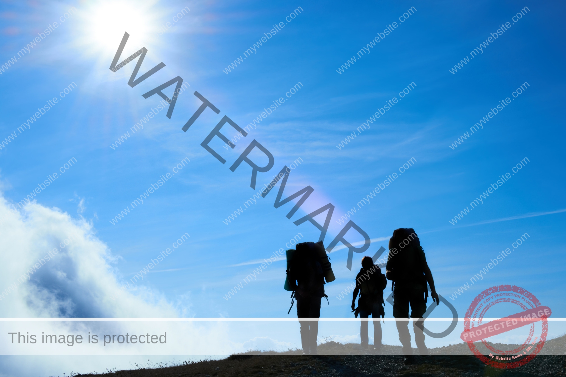 Silhouette of hiking friends against sun and blue sky